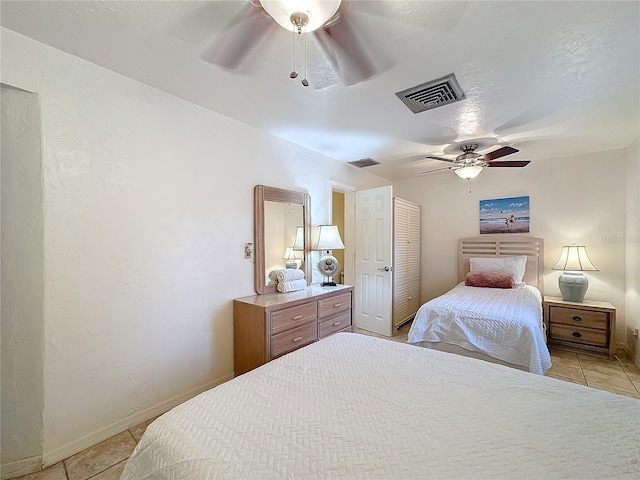 bedroom with light tile patterned floors, a closet, and ceiling fan