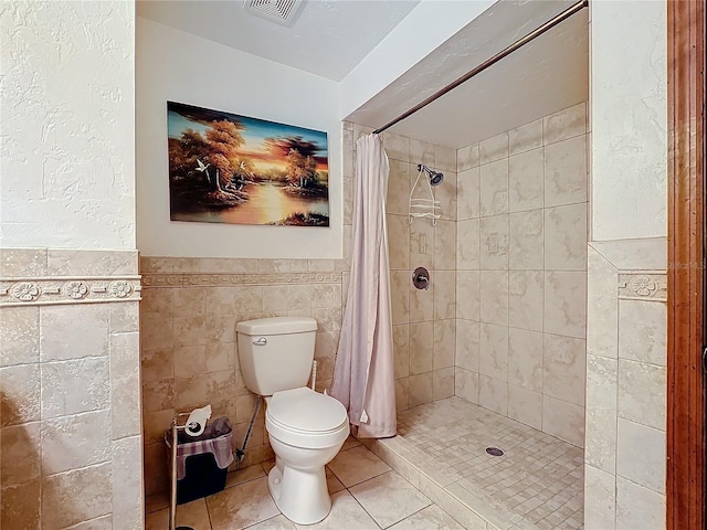 bathroom featuring toilet, tile walls, tile patterned floors, and a shower with curtain