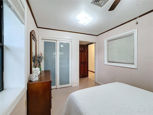 bedroom featuring ornamental molding, a closet, and ceiling fan