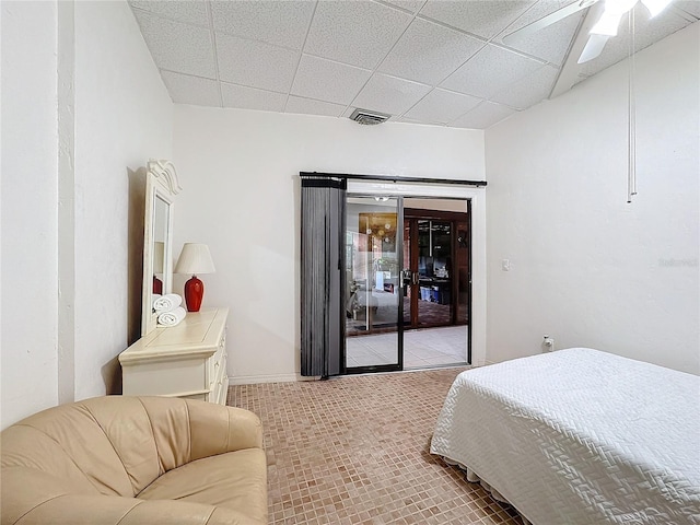 bedroom with a drop ceiling, access to exterior, and ceiling fan