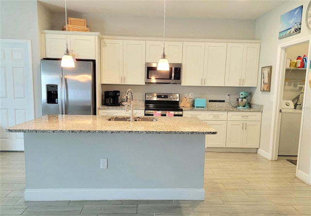 kitchen with light stone counters, sink, stainless steel appliances, and white cabinets