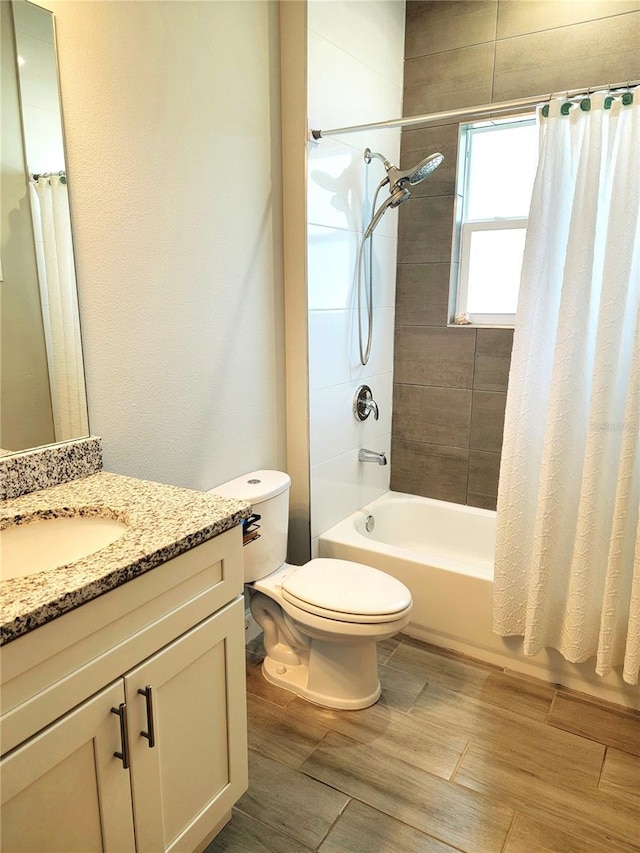 full bathroom with shower / tub combo with curtain, vanity, and toilet