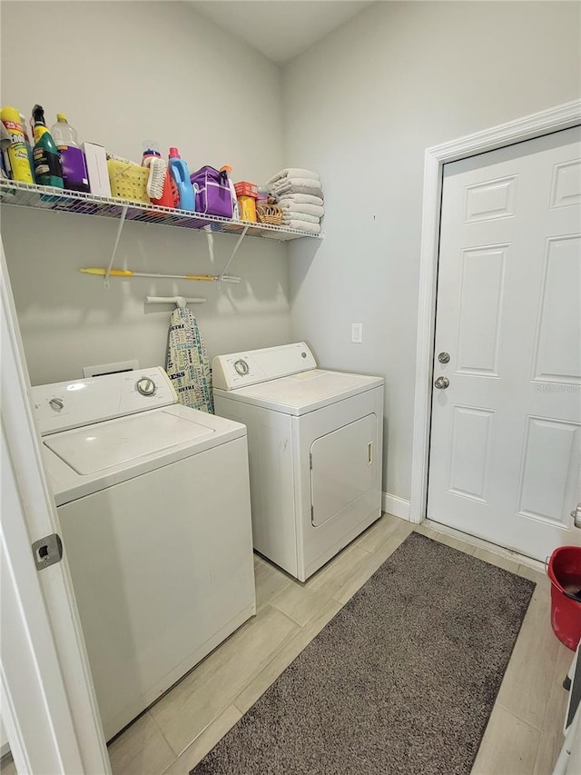 laundry area featuring washing machine and dryer and light wood-type flooring