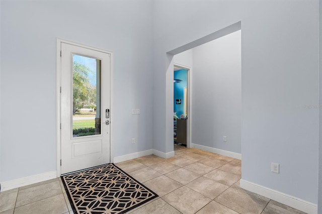 foyer with baseboards and light tile patterned flooring