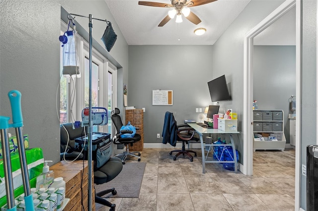 home office featuring a textured ceiling, tile patterned flooring, a ceiling fan, and baseboards