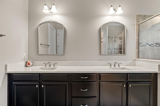 full bathroom featuring a tile shower, double vanity, and a sink