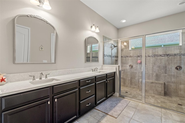 bathroom with double vanity, tile patterned flooring, a shower stall, and a sink