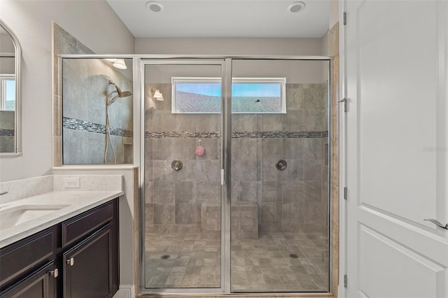 full bathroom with a stall shower, plenty of natural light, and vanity