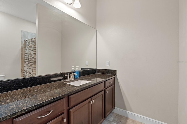 bathroom featuring a shower with shower curtain, baseboards, and vanity