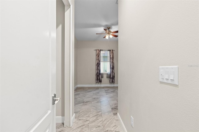 hall featuring marble finish floor and baseboards