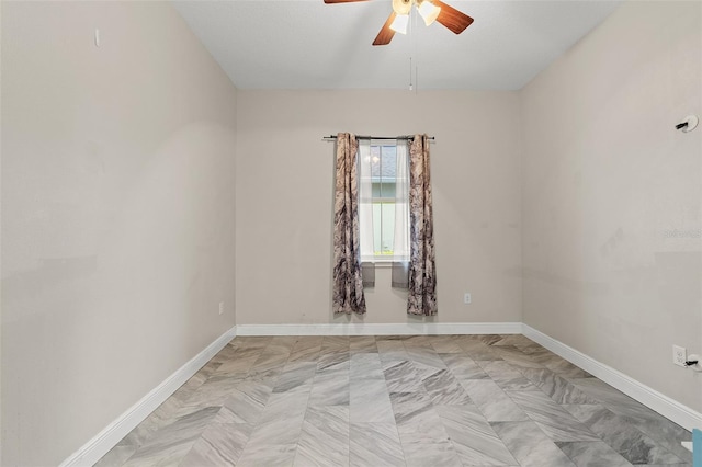 unfurnished room with ceiling fan and baseboards