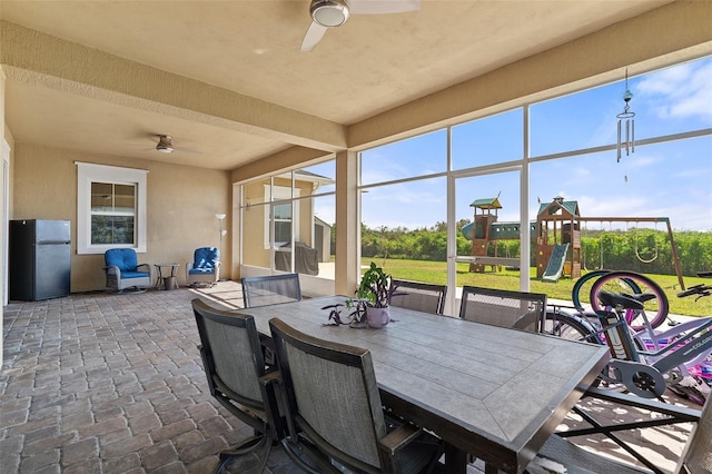 view of patio / terrace featuring a ceiling fan, a playground, and outdoor dining space