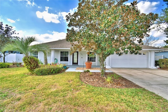 view of property hidden behind natural elements featuring a garage and a front lawn