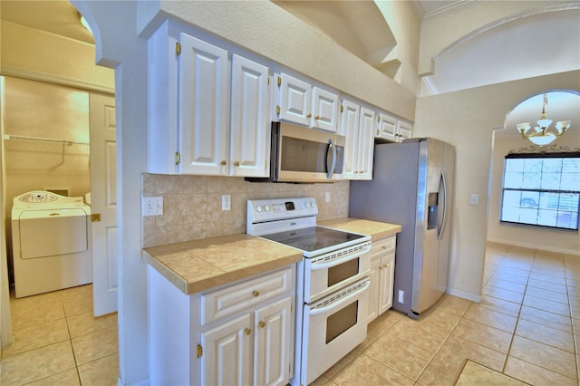 kitchen featuring white cabinetry, washer / dryer, stainless steel appliances, and light tile patterned flooring