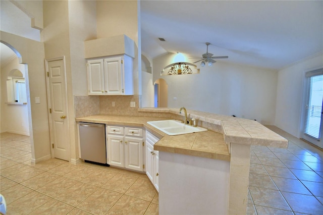 kitchen featuring light tile patterned flooring, sink, dishwasher, kitchen peninsula, and white cabinets