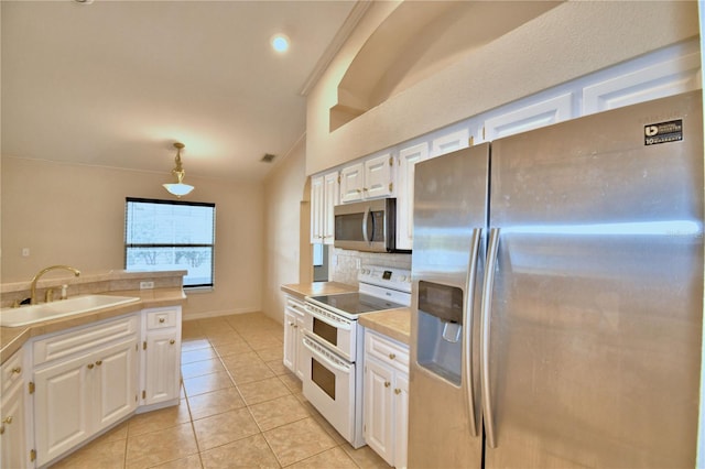 kitchen with appliances with stainless steel finishes, decorative light fixtures, white cabinetry, sink, and light tile patterned floors