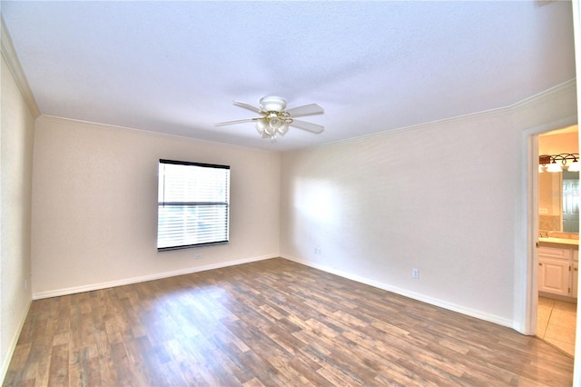 spare room featuring ceiling fan, ornamental molding, and dark hardwood / wood-style floors