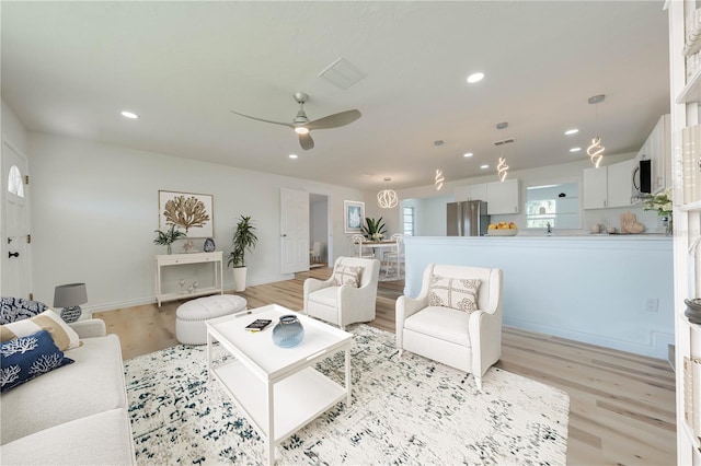 living room featuring ceiling fan and light wood-type flooring