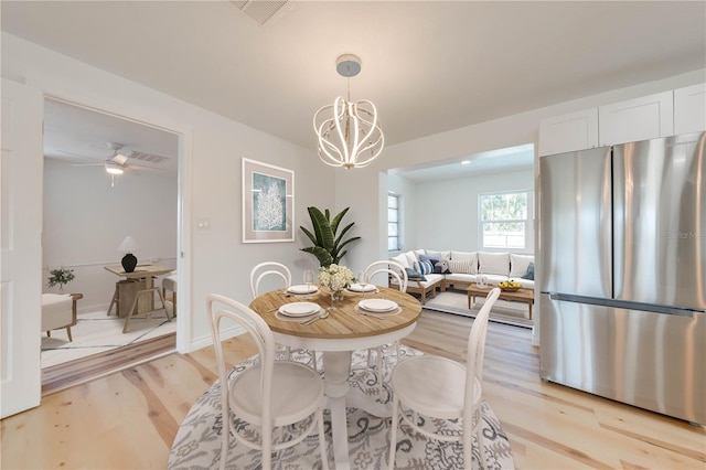 dining space featuring an inviting chandelier and light hardwood / wood-style flooring