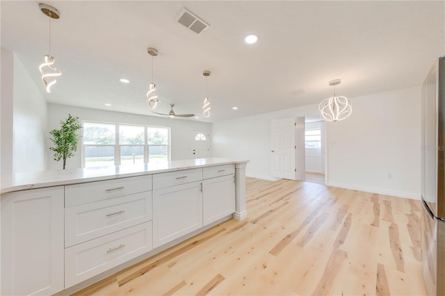 kitchen featuring white cabinetry, plenty of natural light, and hanging light fixtures