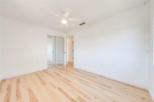 empty room with ceiling fan and light hardwood / wood-style flooring