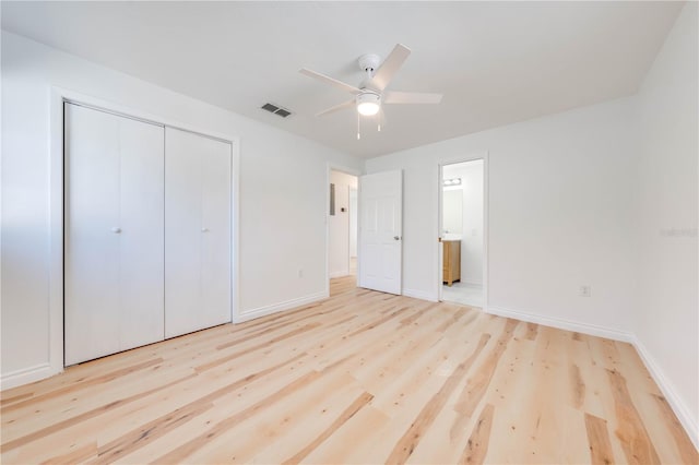 unfurnished bedroom with ceiling fan, connected bathroom, a closet, and light wood-type flooring