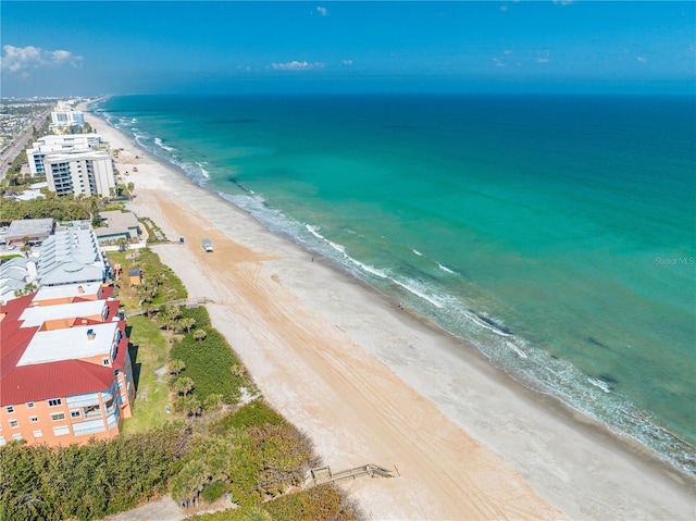 drone / aerial view featuring a water view and a beach view