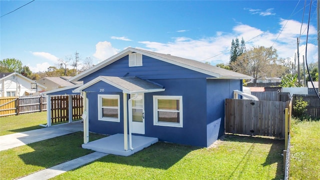 back of house featuring a patio area, a lawn, fence, and stucco siding