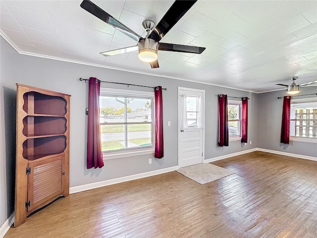 foyer entrance featuring crown molding, baseboards, a ceiling fan, and wood finished floors