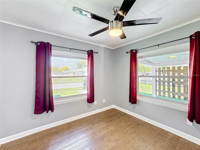 unfurnished room featuring ceiling fan, baseboards, wood finished floors, and ornamental molding