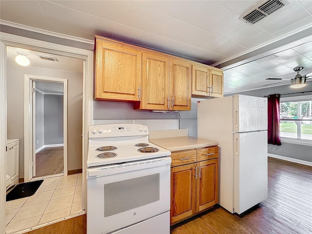 kitchen featuring light countertops, white appliances, visible vents, and light wood finished floors