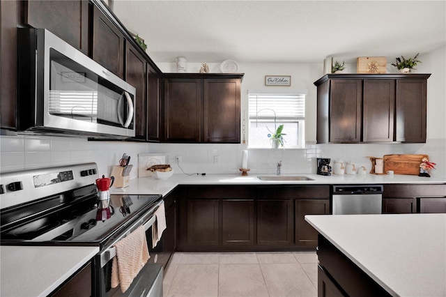 kitchen with sink, decorative backsplash, dark brown cabinets, and stainless steel appliances