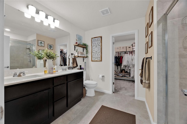 bathroom with vanity, toilet, tile patterned flooring, and a shower with door