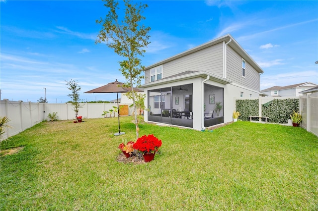 rear view of property featuring a lawn and a sunroom