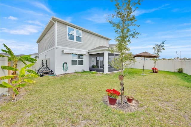 back of property featuring a sunroom and a yard