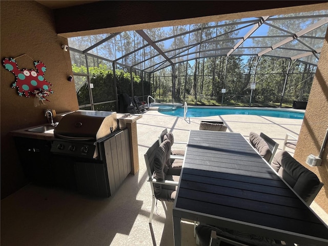 outdoor pool featuring a lanai, a patio area, a grill, and a sink