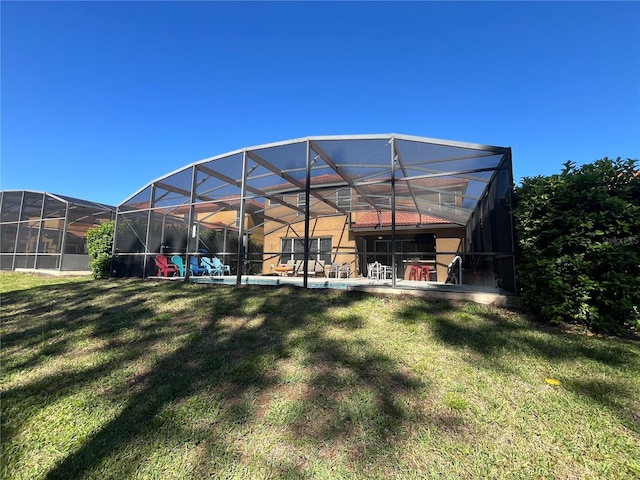 rear view of property with a lanai and a lawn