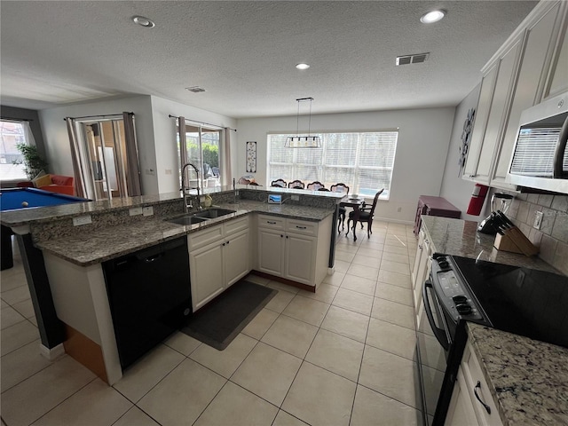 kitchen featuring black appliances, plenty of natural light, visible vents, and a sink