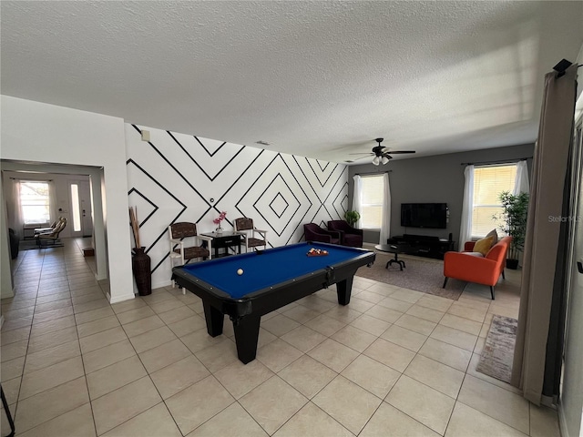 recreation room featuring pool table, plenty of natural light, a textured ceiling, and light tile patterned flooring