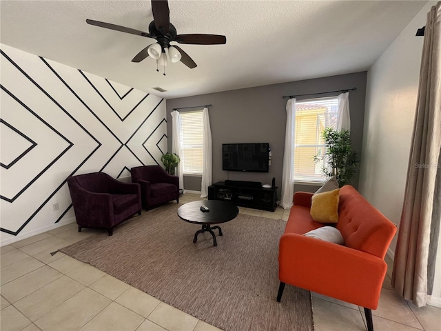 living room featuring visible vents, ceiling fan, a textured ceiling, and a wealth of natural light