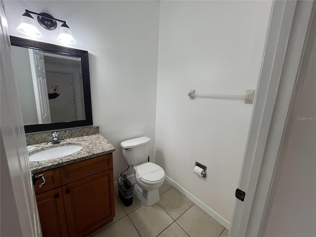 bathroom with baseboards, vanity, toilet, and tile patterned floors