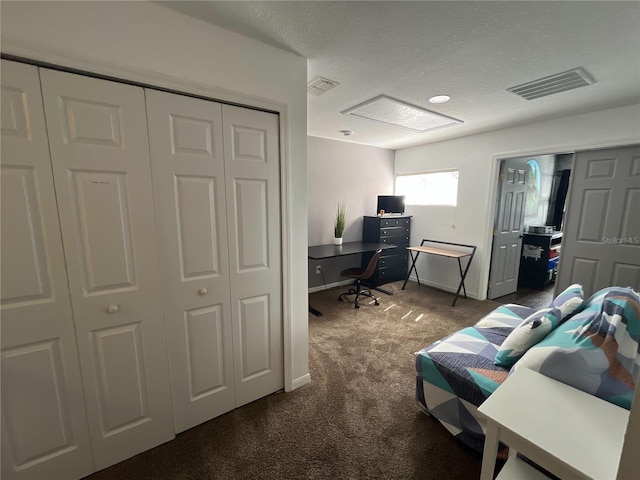 carpeted office space featuring a textured ceiling, visible vents, and baseboards