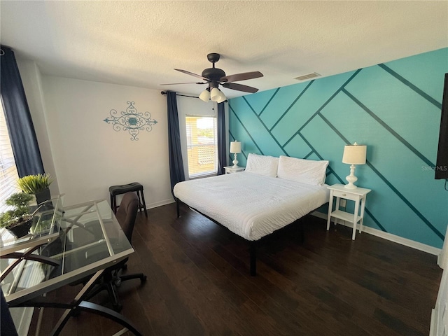 bedroom featuring baseboards, visible vents, ceiling fan, wood finished floors, and a textured ceiling