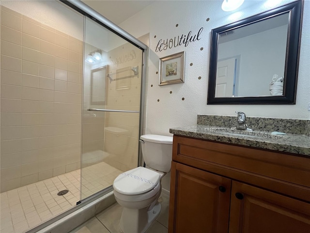 bathroom featuring toilet, a stall shower, tile patterned floors, and vanity