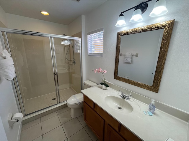 bathroom featuring tile patterned flooring, a shower stall, toilet, and vanity