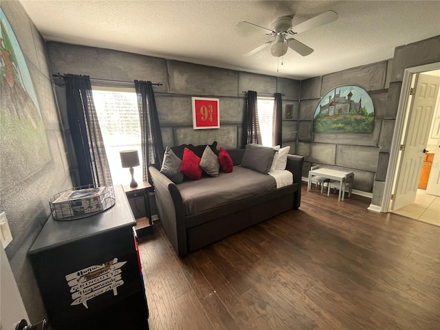 bedroom featuring a ceiling fan, a textured ceiling, and wood finished floors