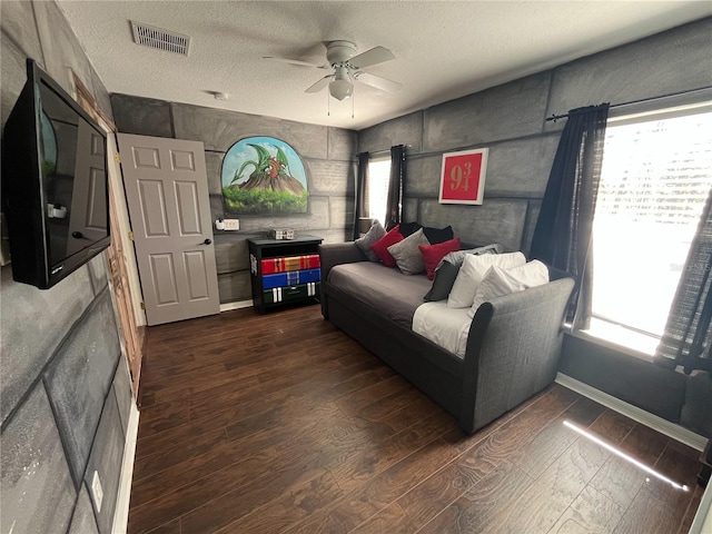 living area with dark wood-style floors, plenty of natural light, and visible vents