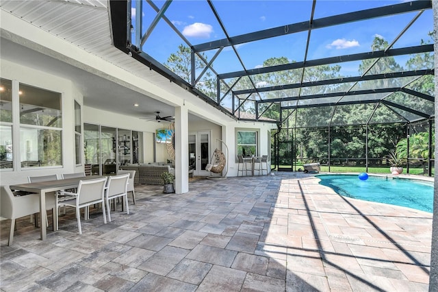 view of pool featuring a patio, outdoor lounge area, ceiling fan, and glass enclosure