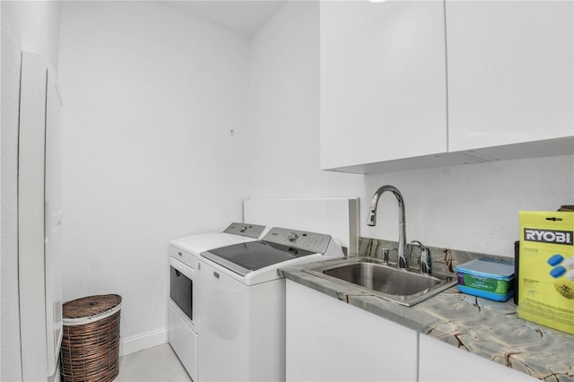 laundry area featuring sink, cabinets, and independent washer and dryer