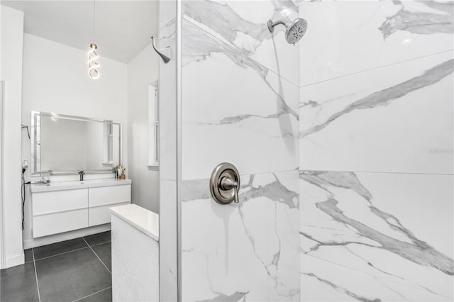 bathroom featuring tile patterned flooring, vanity, and a tile shower